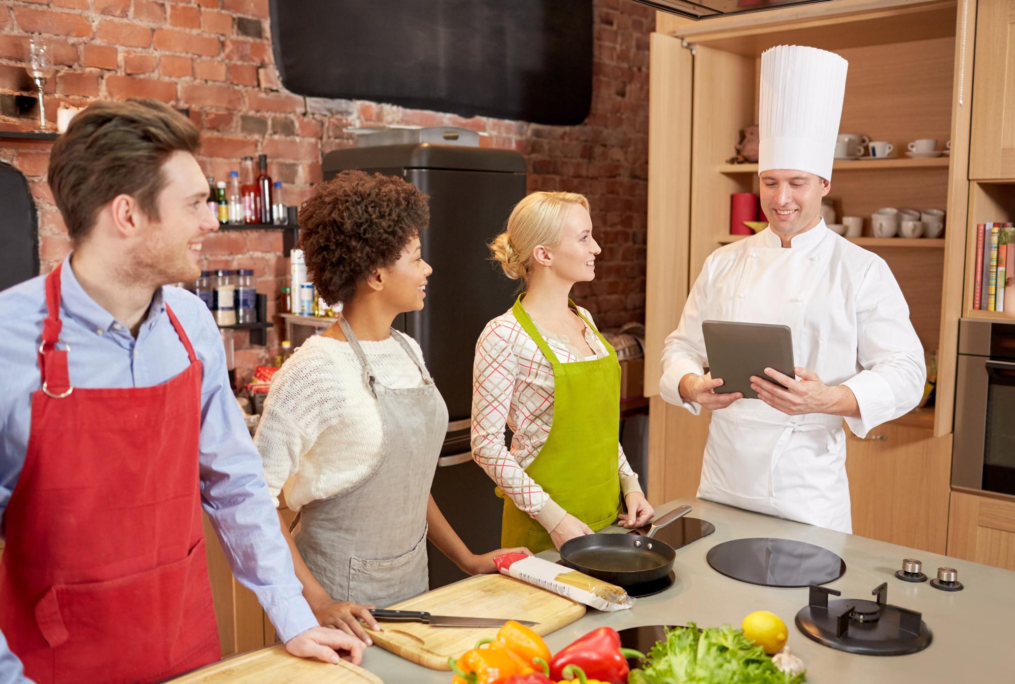 Workshop kitchen with chef instructing a small group