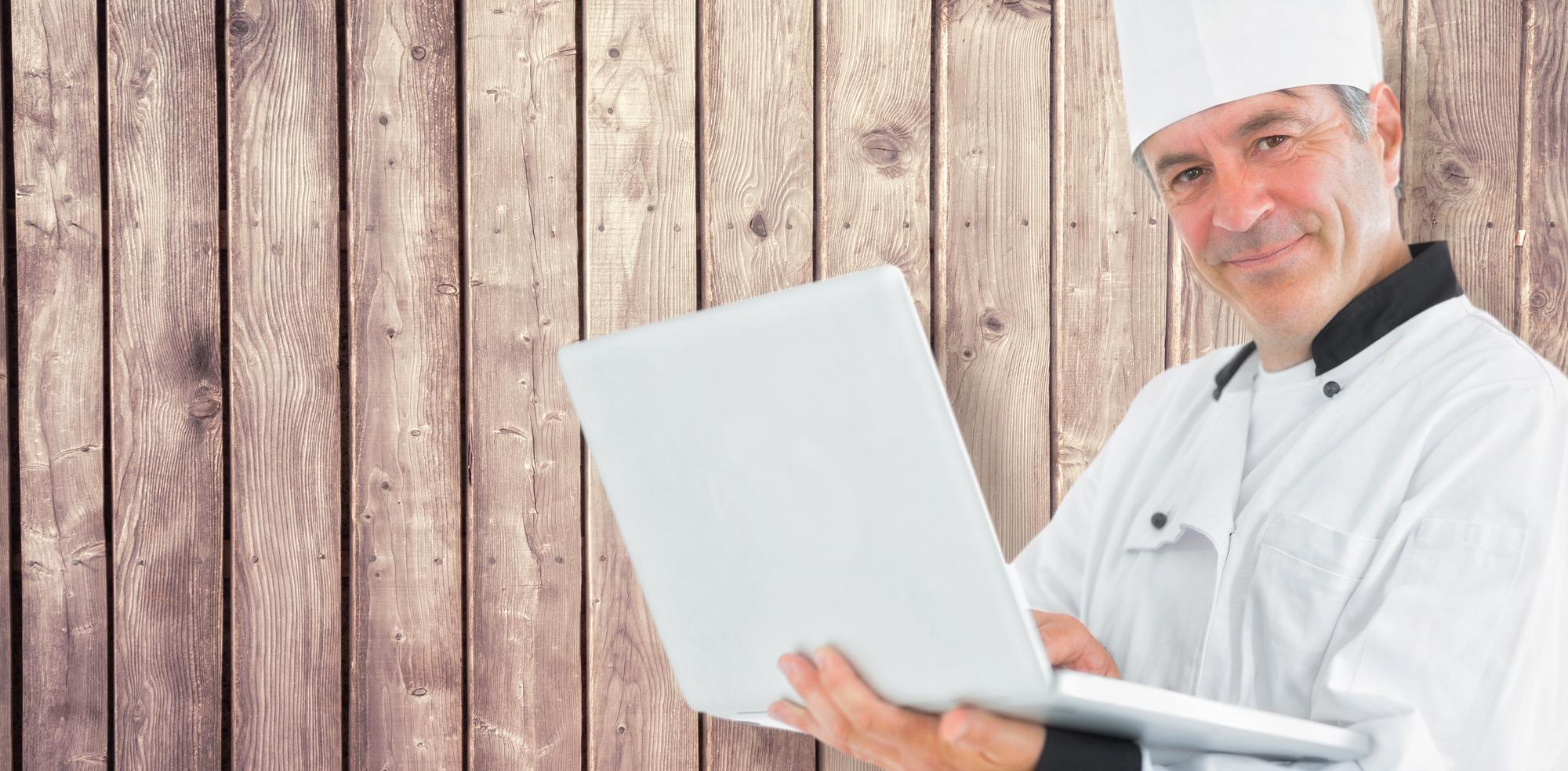 Chef consulting over menu notes at wooden table